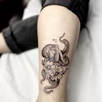 tatouage de pieuvre et fleurs sur le mollet en noir