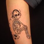 Tatouage d'un squelette sur un avant bras en encre noire