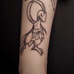 Tatouage de type pokemon en noir sur le bras